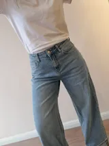 Pantalón de jean wide leg, tiro medio-alto, color celeste con lavado vintage, corte amplio y dobladillo ancho fijo en los tobillos.