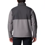 Chaqueta Columbia Ascender Soft Shell con diseño bicolor en tonos gris y gris oscuro. Cuenta con cierre frontal completo, cuello alto con protector de mentón, bolsillo en el pecho con cierre, bolsillos laterales con cierre y puños ajustables con velcro.