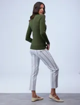 Buzo rojo de tejido fino con cuello redondo y mangas largas. Detalle de botones dorados en los puños.