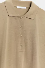 Polo de corte holgado confeccionado en mezcla de lyocell, con cuello solapa, cierre frontal de botones y mangas cortas amplias.