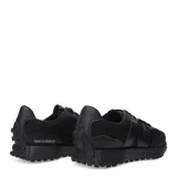 Championes New Balance modelo 327, color negro, con parte superior de malla y superposiciones de cuero sintético. Presenta el logo 'N' sobredimensionado en el lateral y suela exterior con tacos prominentes.