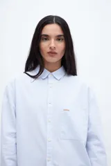 Camisa de algodón a rayas verticales rosas y blancas, con cuello solapa clásico y bolsillo cuadrado en el pecho.