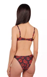 Conjunto de bikini negro con estampado de flores rojas. El corpiño es de corte triangular con breteles finos y la bombacha es de tiro bajo.