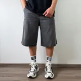 Bermuda de jean corte baggy en color gris oscuro con efecto deslavado, diseño amplio y bolsillos laterales.