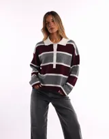 Sweater de punto con diseño a rayas horizontales en tonos gris, bordó y blanco. Presenta cuello tipo polo con tapeta de botones frontal y mangas largas de corte holgado.