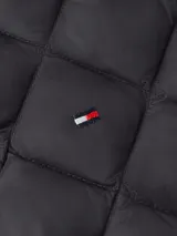 Chaleco negro acolchado con relleno de plumón, sin cuello y cierre a presión.