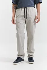 Pantalón de gabardina color azul marino, con diseño de cinco bolsillos, corte relajado, cintura elastizada con cordones ajustables y terminación recta sin puños.