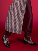 Botas texanas cortas de cuero sintético negro con detalles en animal print y cierre lateral.