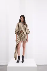 Minifalda de tafeta con diseño de rayas verticales en tonos bronce y beige. Presenta un estilo drapeado con un lazo lateral largo y caída fluida.