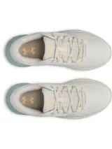 Championes de trail running Under Armour Charged Bandit TR 3 para mujer, color blanco hueso con detalles en naranja y suela intermedia en verde menta. Presentan el logo de Under Armour en el talón y tecnología Charged en la amortiguación.