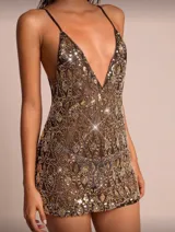 Vestido corto negro con bordados dorados y lentejuelas, escote en V profundo y breteles finos. Espalda descubierta.