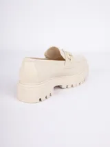 Mocasín negro de cuero sintético con aplique metálico plateado y suela de plataforma track.