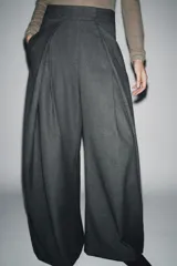 Pantalón de tiro medio con corte wide leg, confeccionado en tejido con viscosa y diseño de raya diplomática. Presenta pinzas frontales, bolsillos laterales ocultos y cierre frontal con cremallera, botón y ganchos metálicos.