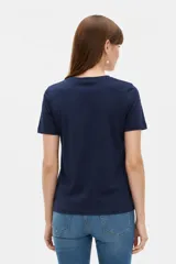 Remera blanca de manga corta y cuello redondo, confeccionada en algodón, con un diseño holgado y estampado frontal de estrella roja con textura y detalles de estrellas pequeñas.