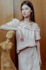 Blusa rosa de lino con escote off shoulder y volados.