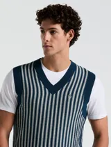 Chaleco de punto con escote en V, color azul marino con rayas verticales blancas y logo bordado en el pecho.