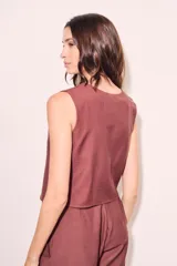 Chaleco negro con escote en V y cierre frontal con botones.