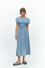 Vestido midi celeste con cuello redondo, mangas cortas y punto panal elastizado en la zona del busto.