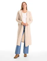 Cardigan largo tipo duster con capucha, de frente abierto y manga larga. Presenta un diseño minimalista en color beige con bolsillos laterales discretos.