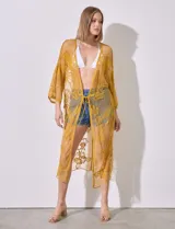 Kaftan largo color amarillo mostaza, de micro tul bordado con motivos florales. Tiene mangas largas y cordón ajustable en la cintura.