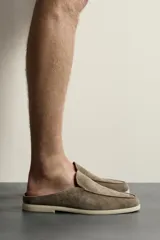 Mocasín destalonado de hombre fabricado en piel con acabado en gamuza, color marrón claro, con detalle de bordón en la parte superior, horma redonda y suela plana a contraste.