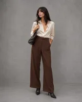 Pantalon de vestir color marron, de corte recto y tiro alto, con cintura estructurada y cierre frontal. Presenta una silueta amplia y fluida.