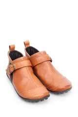 Bota baja de cuero color marrón, estilo botín con elásticos laterales y tira con hebilla metálica ajustable. Cuenta con costuras decorativas pespunteadas y suela de goma con relieve.