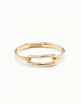 Pulsera rígida de diseño minimalista con eslabón central tipo clip, bañada en oro de 18k.