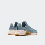 Championes de entrenamiento Reebok Nano X4 color celeste con suela tostada y detalles en tono rosado claro. Presentan capellada de malla transpirable, cordones tono sobre tono y refuerzo lateral característico de la línea Nano con el logo de la marca.