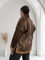 Buzo de micropana con estampado animal print, cuello polo con cierre de cremallera metálica dorada y puños y ruedo con ribete de corderito color beige.