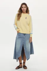 Sweater tejido de punto de cuello redondo y manga raglán, color amarillo con detalles en blanco en las mangas, puños celestes y bordado de un velero en el pecho.