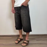 Bermuda de jean negro con corte ancho y largo a la rodilla.