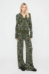 Pantalón de tricot verde militar con estampado paisley en tonos blancos y negros, tiro medio, cintura elástica con cordón ajustable y corte ancho y holgado.