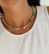 Collar de diseño artesanal que combina piedras naturales en tonos verdes y turquesas con perlas irregulares y pequeñas cuentas doradas.