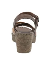 Sandalias de cuero RKF modelo Dalia, con tacón ancho efecto corcho y plataforma. Posee tiras cruzadas en la parte delantera en tonos marrón, terracota, tostado y beige, y tira al tobillo con hebilla metálica.