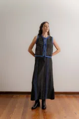 Falda larga tejida con diseño calado, presenta rayas verticales en contraste de color azul que estilizan la figura y tajos laterales en el ruedo.