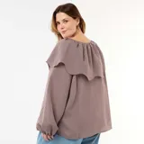 Blusa fluida de manga larga con diseño a rayas en tonos marrón y blanco, con escote redondo adornado con una pequeña abertura y tiras para anudar, y un gran volante superpuesto en los hombros.