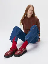 Sweater de punto con cuello polera, diseño a rayas verticales en tonos azules y logo bordado en color amarillo en el pecho. Presenta puños y ruedo ajustados.