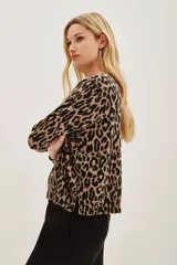Sweater de punto con estampado de leopardo en tonos marrón y negro, de manga larga y cuello redondo. Presenta detalles de lentejuelas negras aplicadas sobre el tejido. Confeccionado en una mezcla de poliamida, acrílico, cachemira y seda.