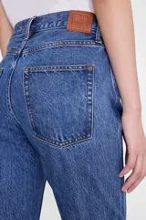 Jean de denim azul oscuro, de tiro alto y corte flare con pernera ancha acampanada.
