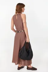 Vestido midi verde de lino italiano, con diseño sin mangas, cuello redondo y estampado de líneas onduladas punteadas. Cuenta con bolsillos laterales.
