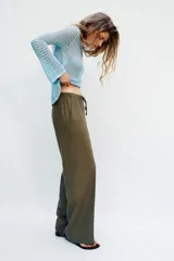 Pantalón recto de lino color verde militar, de tiro medio con cintura elástica ajustable mediante cordón y bolsillos delanteros.