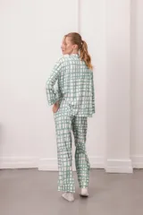 Conjunto de pijama de dos piezas, color verde menta con estampado de cuadros irregulares en blanco. Incluye camisa de manga larga con botones y pantalón largo con cintura elástica.