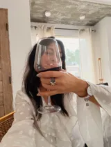 Blusa blanca con estampado de lunares, confeccionada en tela semitransparente. Presenta escote en V con volados frontales y mangas largas acampanadas con volados en los puños.