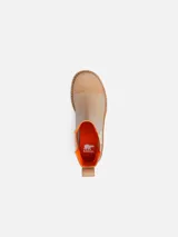 Bota tipo Chelsea de cuero color beige, con paneles laterales elásticos, tirador en el talón con detalle naranja y suela de caucho dentada con tacón.