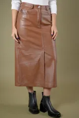 Pollera midi de cuero ovino con diseño tipo jean, cierre frontal con botón y tajo central.