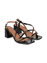 Sandalia de taco alto cuadrado, color negro charol, con diseño de tiras finas cruzadas y cierre de hebilla metálica en el tobillo.
