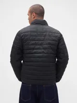 Campera puffer de diseño ligero, color verde militar, con cierre frontal completo y cuello alto. Presenta un acabado acolchado horizontal y puños elásticos.