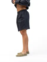 Short de lino con cintura elástica y cordón ajustable. Cuenta con dos bolsillos laterales y un bolsillo trasero, ofreciendo un ajuste cómodo y versátil.