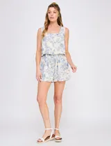 Enterito corto de lino y viscosa, con estampado floral azul sobre base beige, efecto dos piezas, escote cuadrado y cintura elastizada con cordón.